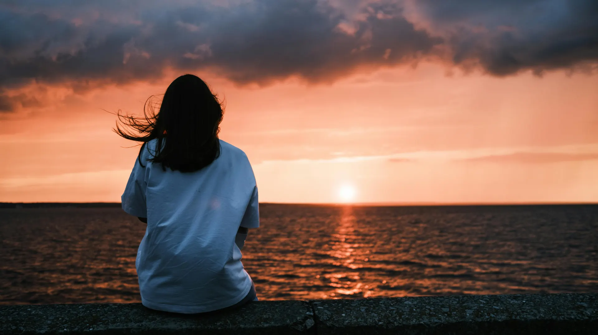 Traveller watching a golden harbour sunset in England