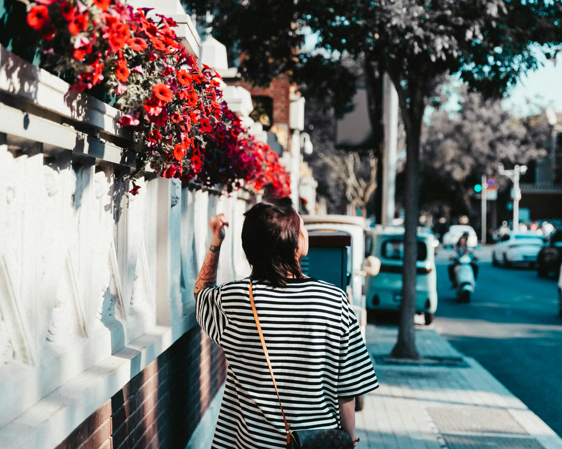 Traveller exploring a flower-filled harbour lane
